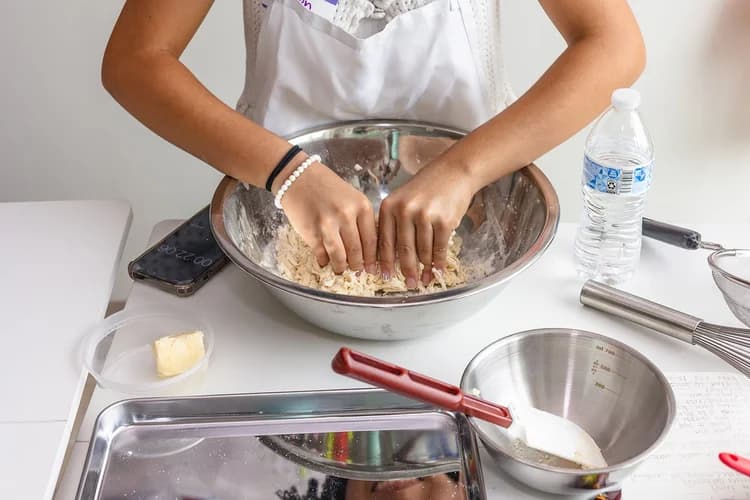 A student practices a hands-on culinary technique